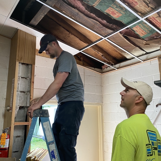 Volunteers repairing ceiling tiles